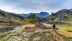 A woman walking on the rugged terrain of Southern Iceland; Grimsnes- og Grafningshreppur, Southern Region, Iceland — Stock Photo