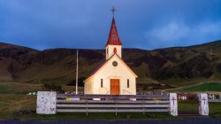 Una iglesia con torre en un remoto pueblo costero en el sur de Islandia; Islandia - foto de stock