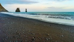 Sea stacks and teal coloured ocean water along the coast of Southern Iceland; Myrdalshreppur, Southern Region, Iceland — Stock Photo