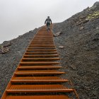 Climbing metal steps up volcanic rock in the rain; Snaefellsbaer, Western Region, Iceland — Stock Photo