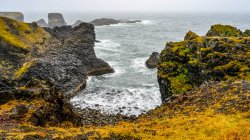 Vista do litoral acidentado com falésias e rochas musgosas, Arnarstapi; Snaefellsbaer, Região Oeste, Islândia — Fotografia de Stock