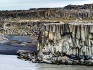 Прочные скалы вдоль Джоколсы на реке Фьоллум у водопада Деттифосс, который считается вторым по силе водопадом в Европе после Рейнского водопада; Скутадареппур, Северо-Восточный регион, Исландия — стоковое фото