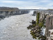 Penhascos rochosos rochosos ao longo de Jokulsa um rio Fjollum na cachoeira Dettifoss; Skutustadahreppur, Região Nordeste, Islândia — Fotografia de Stock