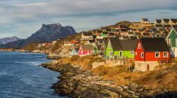 Колірні будинки вздовж скелястого берега Нуук; Нуук, Сермерсук, Гренландія — стокове фото