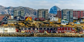 Casas coloridas ao longo da costa rochosa de Nuuk; Nuuk, Sermersooq, Groenlândia — Fotografia de Stock