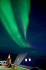 Северное сияние над береговой линией и домами Нуука, Гренландия; Нуука, Сермерсука, Гренландия — стоковое фото