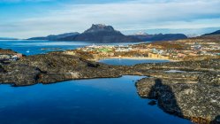 A view of the rugged coastline of Sermersooq and houses in Nuuk; Nuuk, Sermersooq, Greenland — Stock Photo
