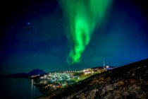 Northern Lights sobre a cidade brilhante de Nuuk; Nuuk, Sermersooq, Groenlândia — Fotografia de Stock