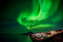 Northern Lights sobre a cidade brilhante de Nuuk; Nuuk, Sermersooq, Groenlândia — Fotografia de Stock