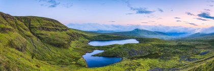 Vista panoramica di due laghi nelle Galty Mountains all'alba, panoramica cucita composita; Contea di Limerick, Irlanda — Foto stock