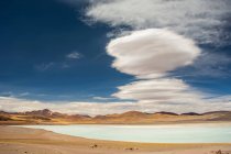 South American high altitude laguna (small lake) with lenticular clouds above; San Pedro de Atacama, Atacama, Chile — Stock Photo