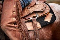 Leatherwork and closer details of a saddle and chaps to the left side; Eastend, Saskatchewan, Canada — Stock Photo