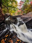 Water from the York River flowing over waterfalls during autumn in Algonquin Provincial Park; Ontario, Canada — Stock Photo