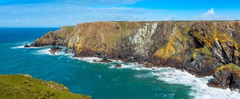 Panorama del litorale roccioso della scogliera con cielo blu; Contea di Cornovaglia, Inghilterra — Foto stock
