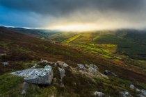 Rocky outcrops on the Silvermine Mountains with the sun rising behind some low clouds; County Tipperary, Ireland — Stock Photo