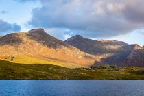 Twelve Bens and Derryclare Lough being hit with the morning rays of sun; Connemara, County Galway, Ireland — Stock Photo