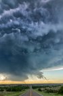 Разрушающаяся сильная гроза, освещаемая молнией, когда она пересекает шоссе; Дарем, Оклахома, Соединенные Штаты Америки — стоковое фото