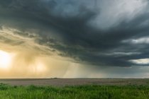 The base of a supercell glows in the sunset as the parent updraft tower leans across the prairie; Arthur, Nebraska, United States of America — Stock Photo