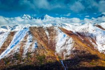 Caída de color montañas de Chugach espolvoreado con nieve, picos irregulares en el fondo. Chugach State Park, South-central Alaska en otoño; Anchorage, Alaska, Estados Unidos de América - foto de stock