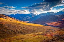 Brooks Mountains and Kuyuktuvuk Creek Valley in fall colours under blue sky. Gates of the Arctic National Park and Preserve, Arctic Alaska in autumn; Alaska, United States of America — Stock Photo