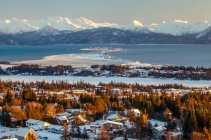 Aerial view of the city of Homer and the Homer Spit in Kenai Peninsula Borough, in Kachemak Bay in winter with the Kenai Mountain Range in the distance; Kenai Peninsula, Alaska, United States of America — Stock Photo