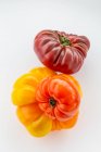 Three varieties and colors of heirloom tomatoes on a white background; Surrey, British Columbia, Canada — Stock Photo