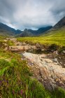 Piccolo fiume a Coire Na Creiche (Le piscine delle fate) vicino Glen Brittle con le colline della cuillina nera in lontananza; Isola di Skye, Scozia — Foto stock