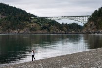 Girl Walking On A Rocky Beach In Deception Pass State Park; Oak Harbor, Washington, United States Of America — стокове фото