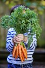 Young Boy Holding A Bunch Of Organic Carrots; Montreal, Quebec, Canada — Stock Photo