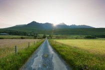 View Along A Road Early In The Morning With The Rising Sun Behind The Black Cuillin Ridge; Glen Brittle, Isle Of Skye, Scotland — Stock Photo