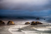 Sunlight And Mist Creating Coast Moods; Cannon Beach, Орегон, Соединенные Штаты Америки — стоковое фото