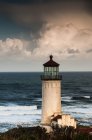 Faro de North Head complementado por nubes y surf; Ilwaco, Washington, Estados Unidos de América - foto de stock