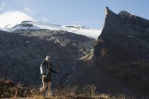 Caminhante feminina ao longo de uma trilha com montanhas acidentadas e geleira no fundo; Áustria — Fotografia de Stock