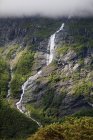 A Stream Running Down A Mountain With Dense Cloud; Andalsnes, Rauma, Noruega — Fotografia de Stock