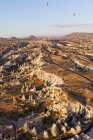 Воздушные шары в полете над прочным ландшафтом, Каппадокия, Турция — стоковое фото