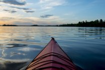 Fiocco di una canoa su un lago tranquillo al tramonto; Ontario, Canada — Foto stock