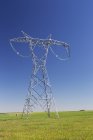 Large Metal Electrical Tower In A Green Field With Blue Sky; Alberta, Canada — стокове фото