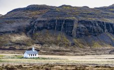 Una iglesia y un pequeño cementerio, que rodea la naturaleza en el oeste de Islandia; Islandia - foto de stock