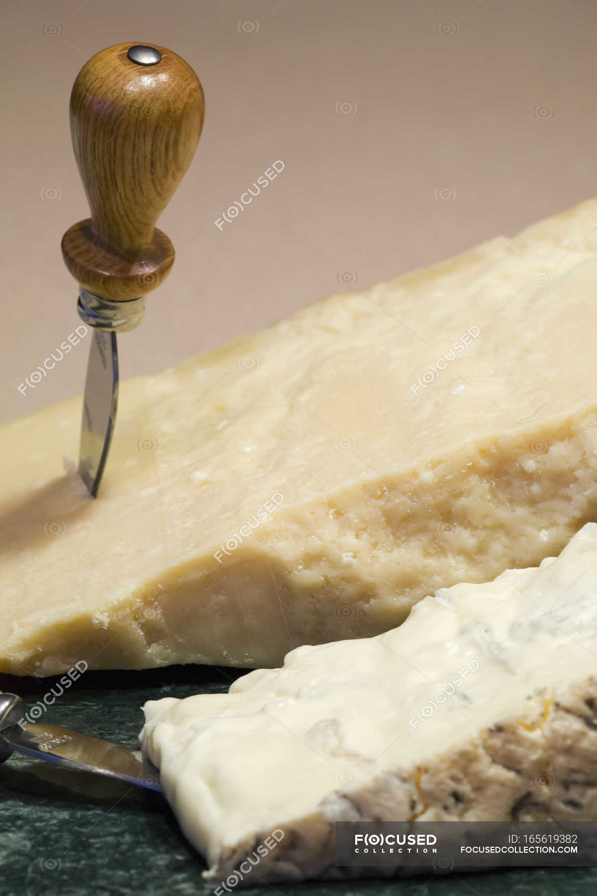 Block of parmesan and cheese on marble round board with