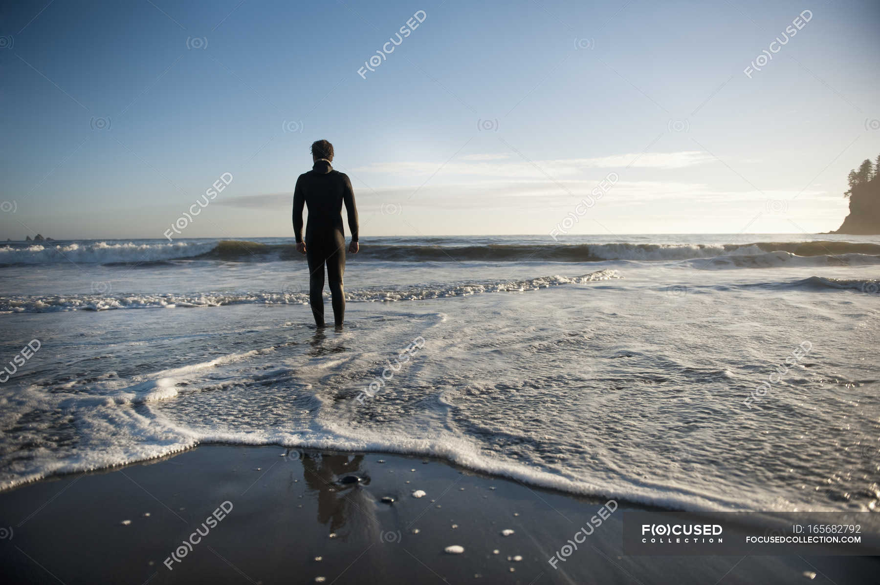 Silhouette Of A Person Standing On A Beach Looking Out Over The Ocean