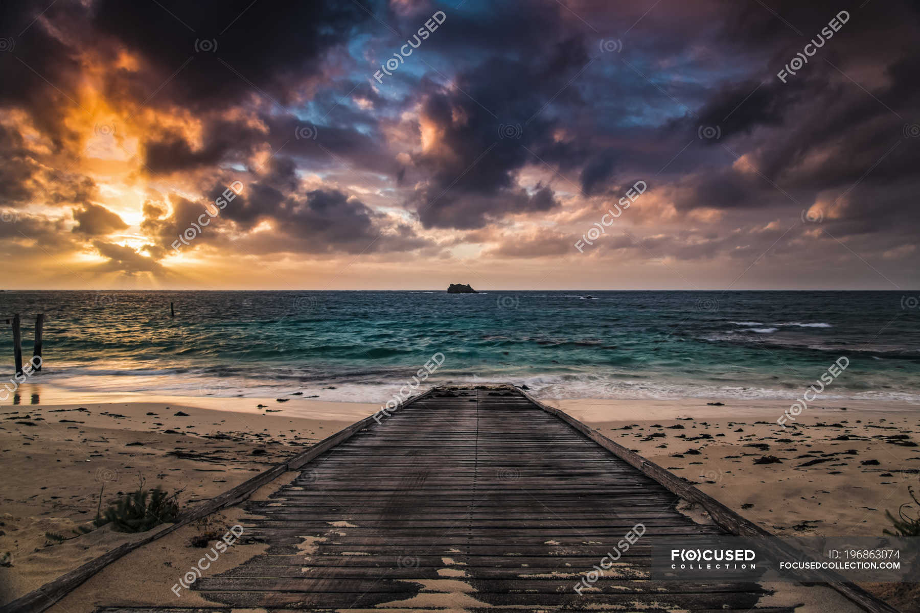 A wooden boardwalk on a beach leading to the turquoise water of Hamelin Bay  at sunset; Western Australia, Australia — backdrop, outdoor - Stock Photo |  #196863074