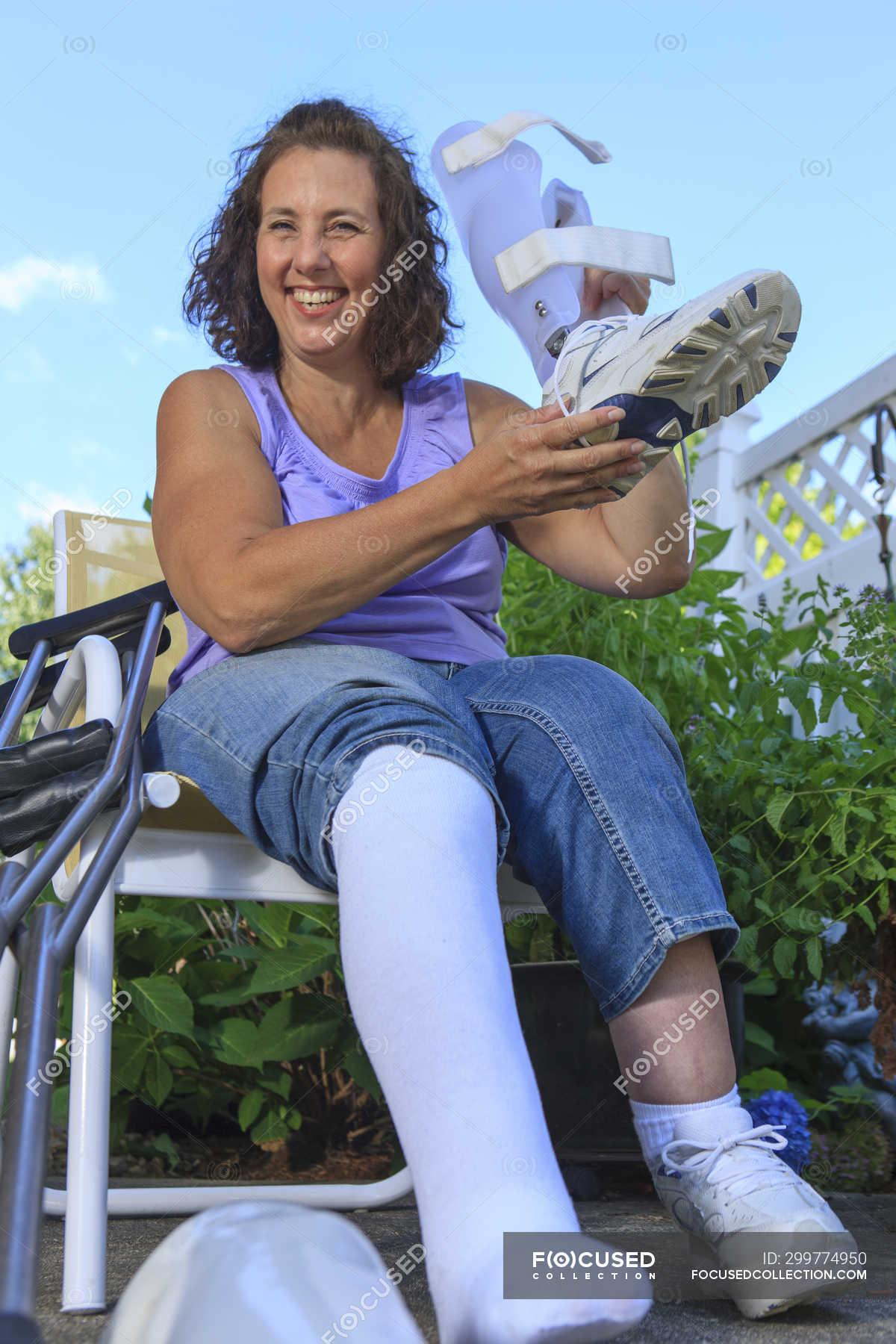 Woman with Spina Bifida adjusting leg brace — rehabilitation