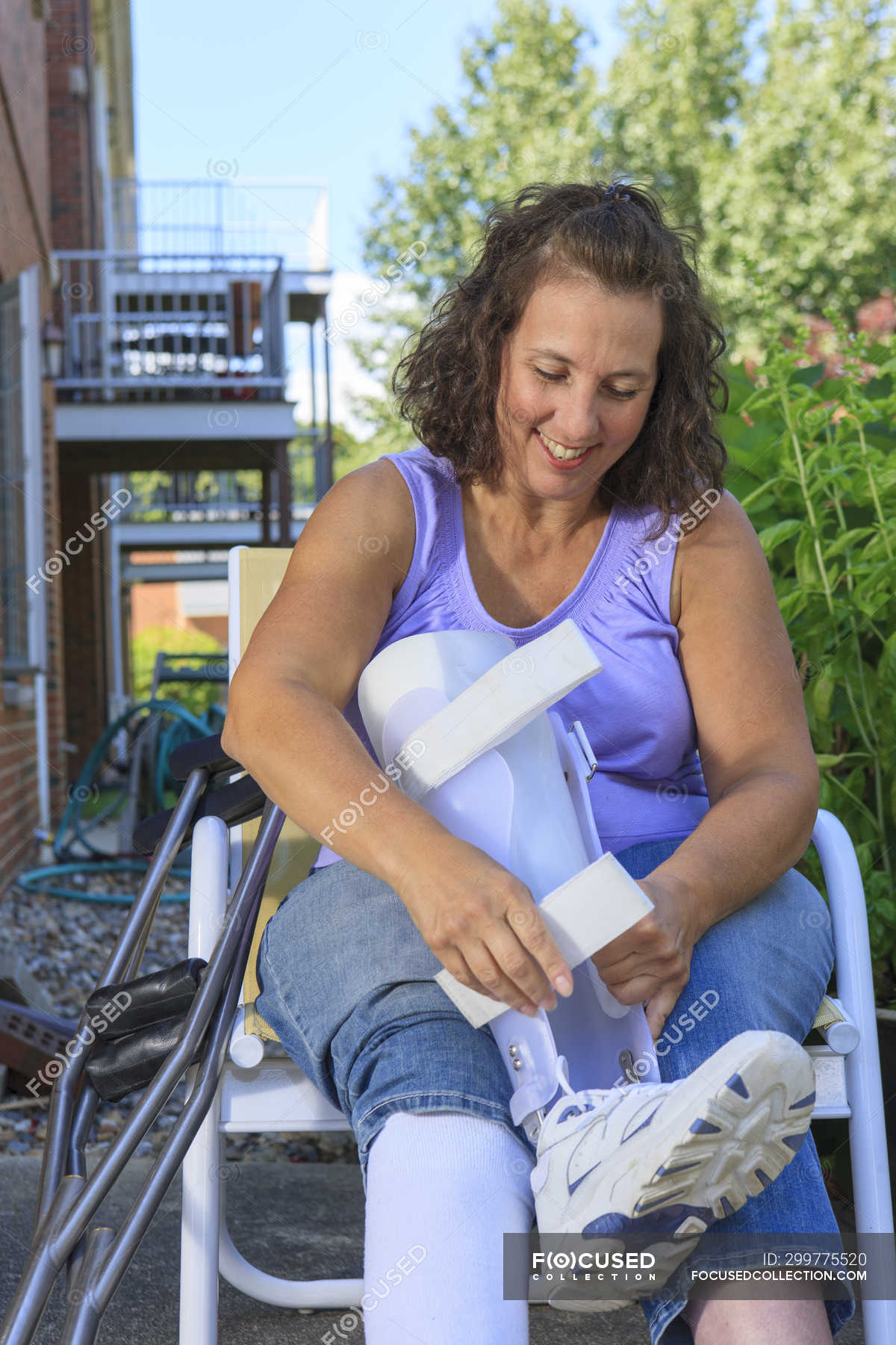Woman with Spina Bifida adjusting leg brace — disease, disability