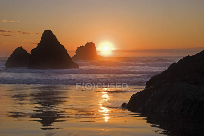 Orangefarbener Sonnenuntergang hinter vorgelagerten Felsen — Stockfoto