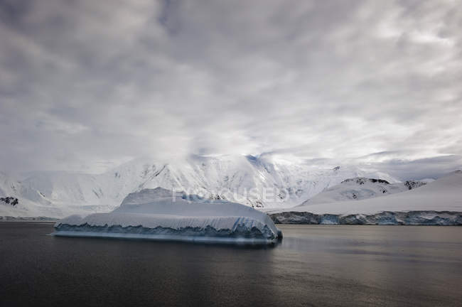 Айсберг в океане и горах — стоковое фото