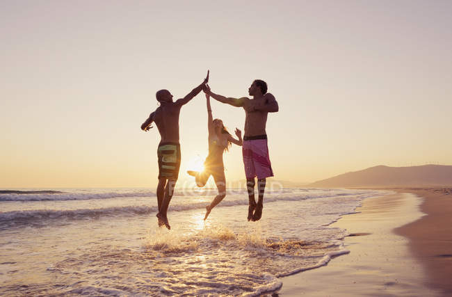Three people leaping in air — Stock Photo