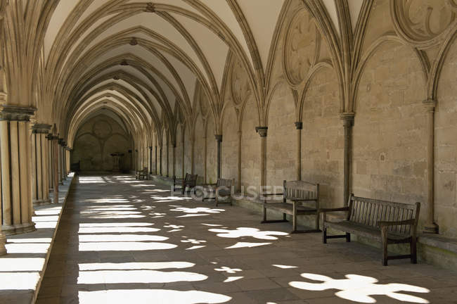 Крытый коридор со скамейками — стоковое фото