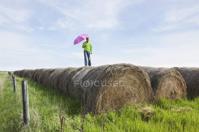 Mujer de pie sobre fardos de heno - foto de stock