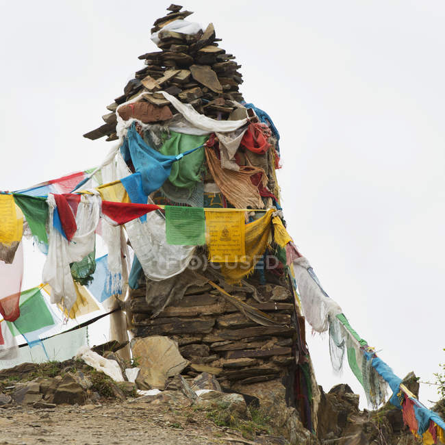 Prayer flags hanging from a cairn — Stock Photo