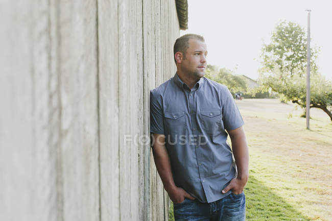 Porträt eines Mannes, der sich an eine Holzwand lehnt; weißer Felsen, britische Kolumbia, Kanada — Stockfoto